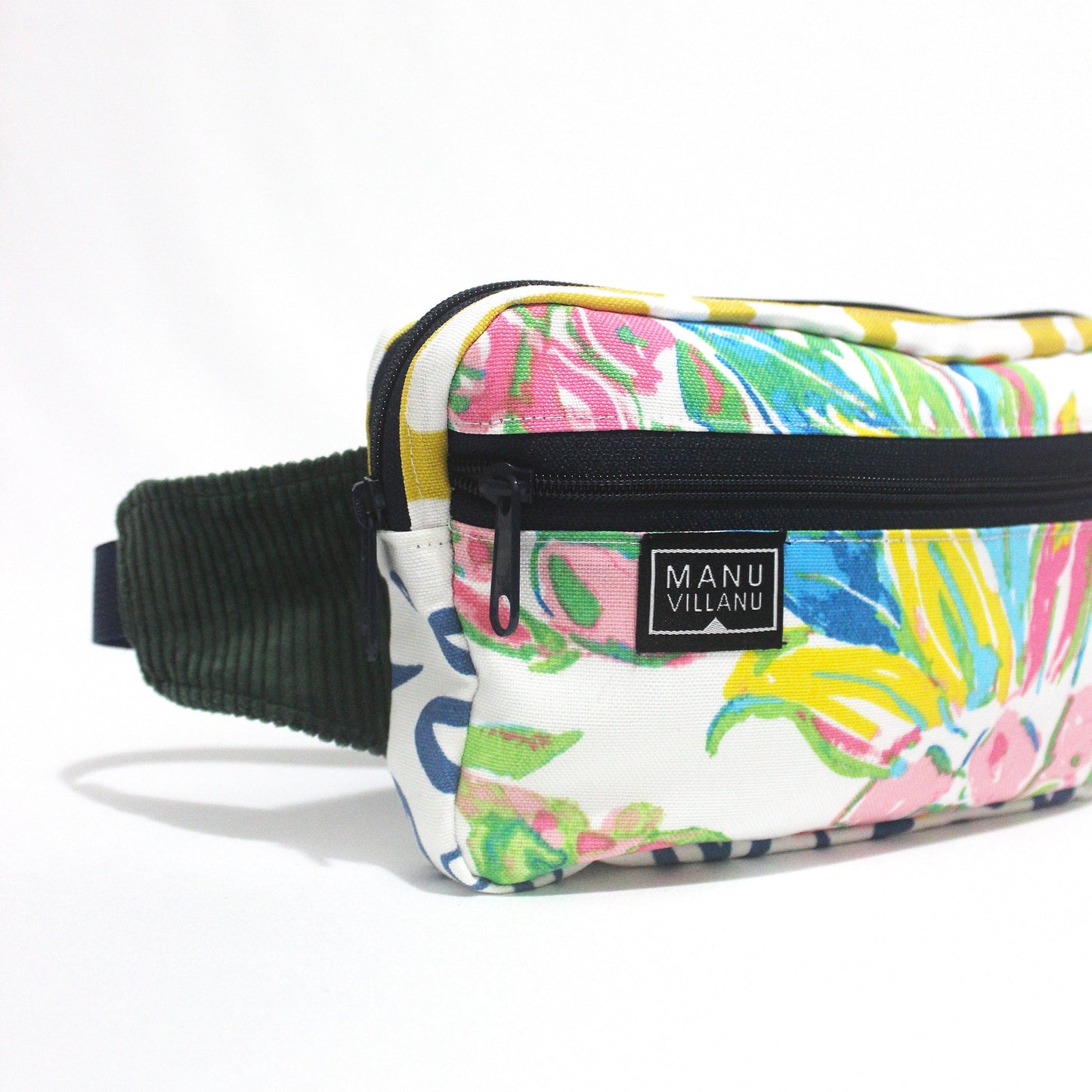 Colorful patterned waist bag with navy strap on a white background