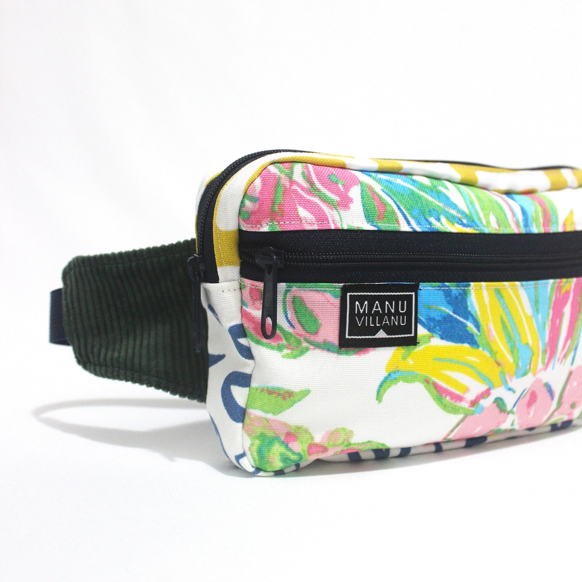 Colorful patterned waist bag with navy strap on a white background